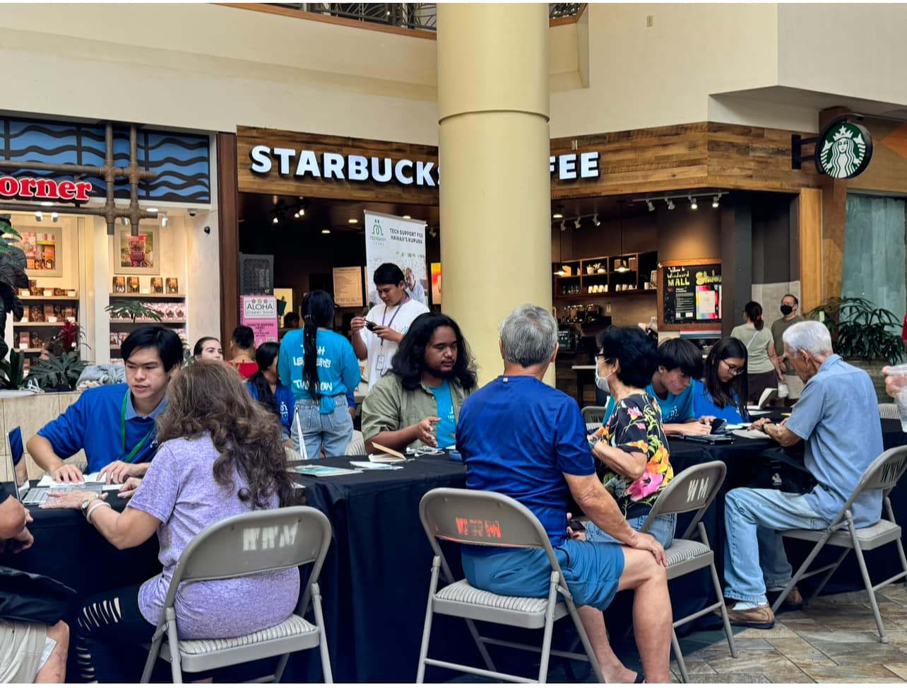 Photo of Brian Li helping people with their technology